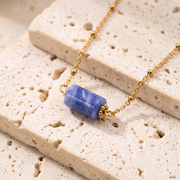 Collier pierre bleue LUMIA® : tube en sodalite entre deux coupelles dorées, sur chaîne fine perlée