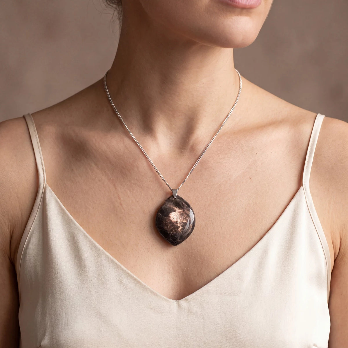 Collier pierre de lune noire porté par une femme, pendentif plat forme libre gris anthracite