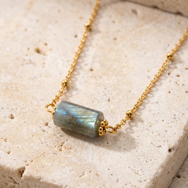 Collier pierre grise LUMIA® : tube en labradorite entre deux coupelles dorées, sur chaîne fine perlée