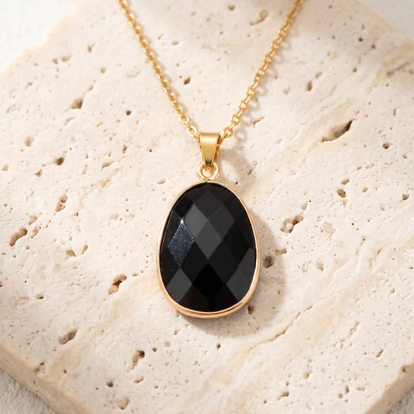 Collier pierre noire FACETTA® : pendentif ovale facetté en obsidienne noire, serti doré sur chaîne fine