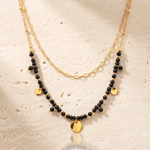 Collier pierre noire CALYA® en onyx noir, double rang doré à médaillons et pampilles