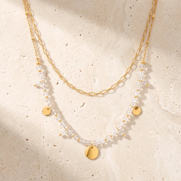 Collier pierre transparente CALYA® en cristal de roche, double rang doré à médaillons et pampilles