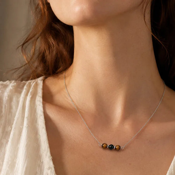 Collier protection en œil de tigre et onyx porté, chaîne fine argentée