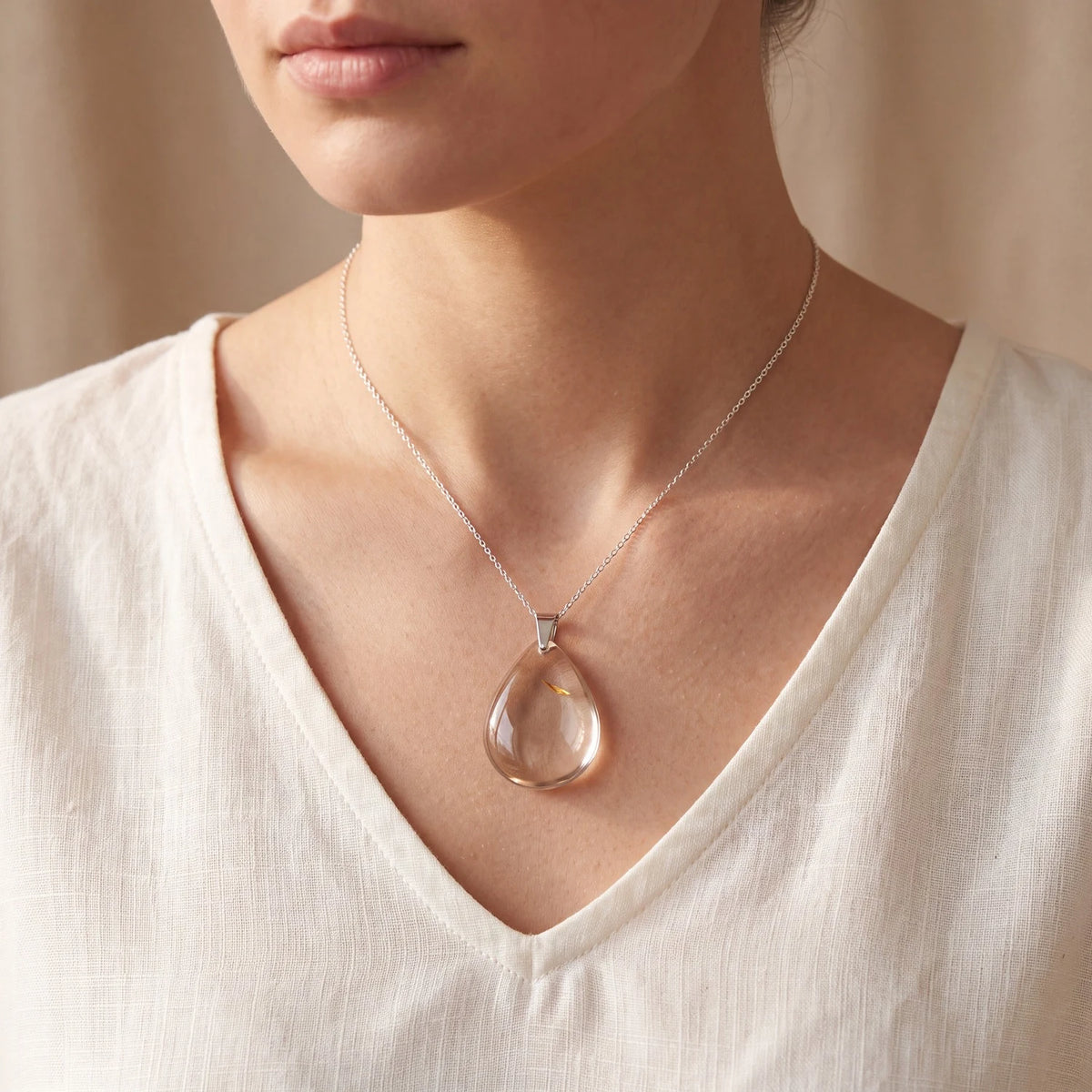 Collier quartz fumé porté par une femme, pendentif goutte plat brun translucide