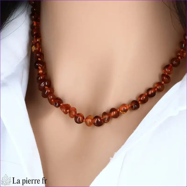 Collier ras de cou en Ambre baroque couleur miel porté, mettant en valeur son élégance naturelle et sa teinte solaire.