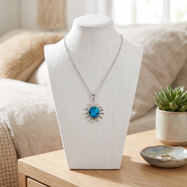 Collier soleil bleu en nacre naturelle porté sur un buste, pendentif soleil sur chaîne argentée