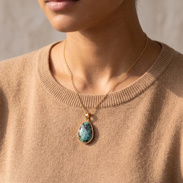 Collier turquoise porté par une femme, pendentif pierre verte sur chaîne dorée