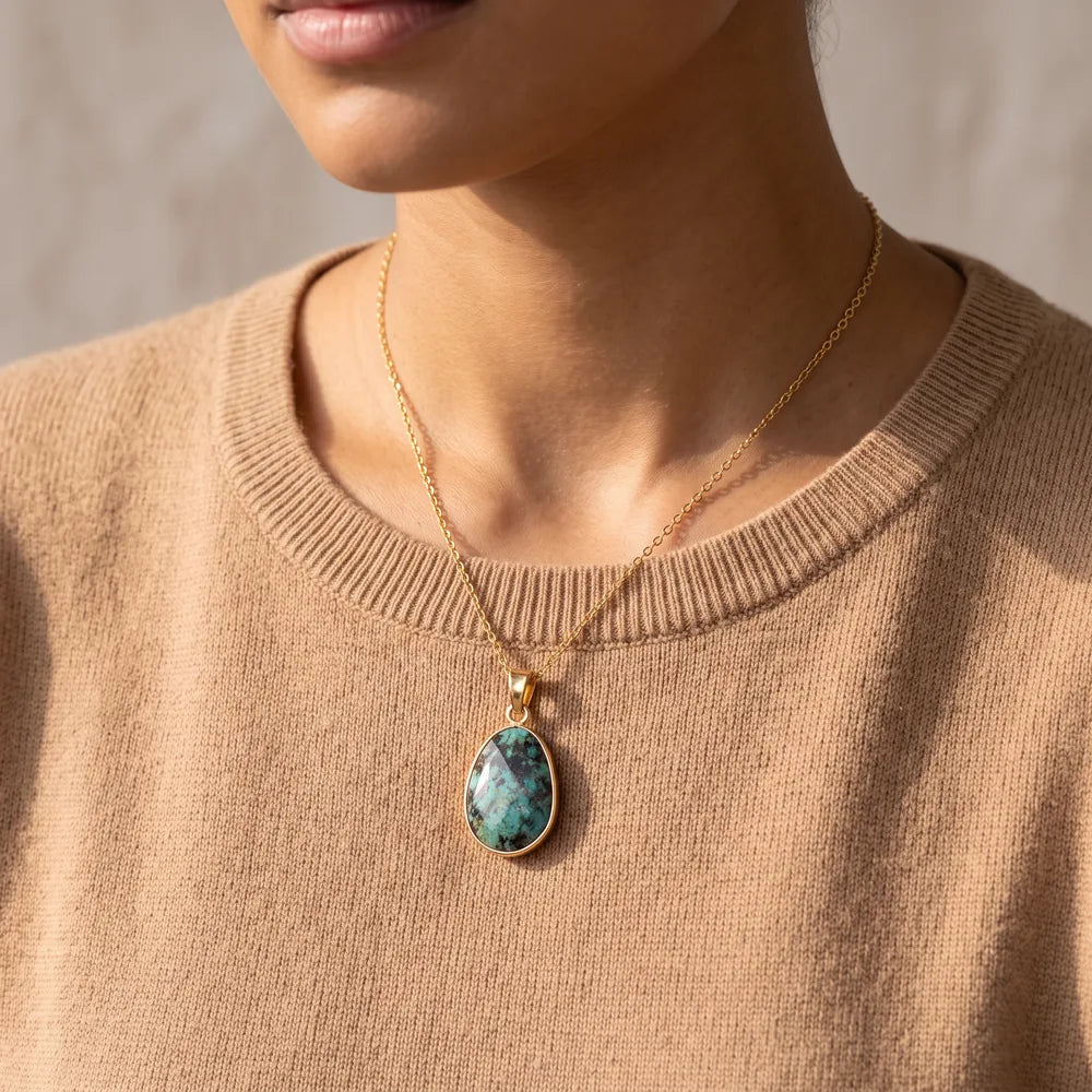 Collier turquoise porté par une femme, pendentif pierre verte sur chaîne dorée