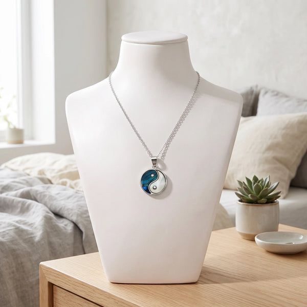 Collier yin yang bleu en nacre naturelle porté sur un buste, pendentif yin yang sur chaîne argentée