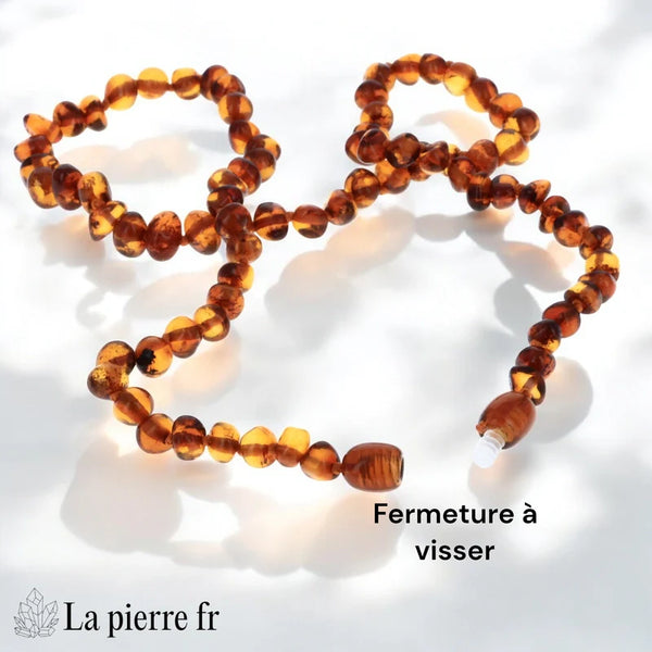Gros plan sur le montage noué et le fermoir à vis d'un collier en Ambre de la Baltique, gage de qualité et de sécurité.