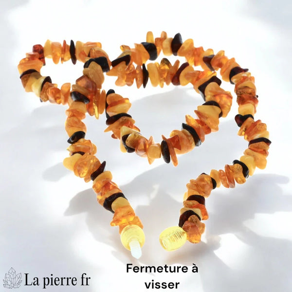 Gros plan sur les perles baroques d'un collier en Ambre véritable, montrant la diversité des formes et des couleurs cognac, jaune et miel.