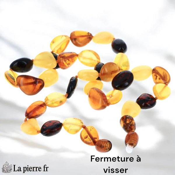 Gros plan sur les perles en forme d'olives d'un collier en Ambre, montrant leurs inclusions naturelles et leur éclat.