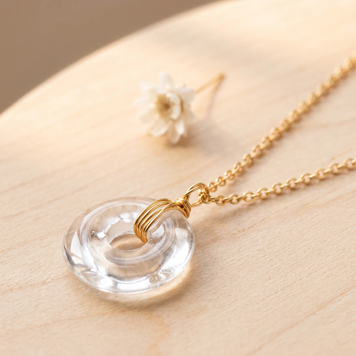 Pendentif cristal de roche en forme de donut, bélière en fil doré enroulé