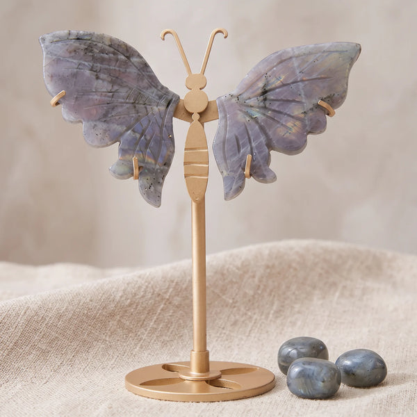 Figurine papillon en labradorite de Madagascar sur un lin naturel avec trois pierres roulées