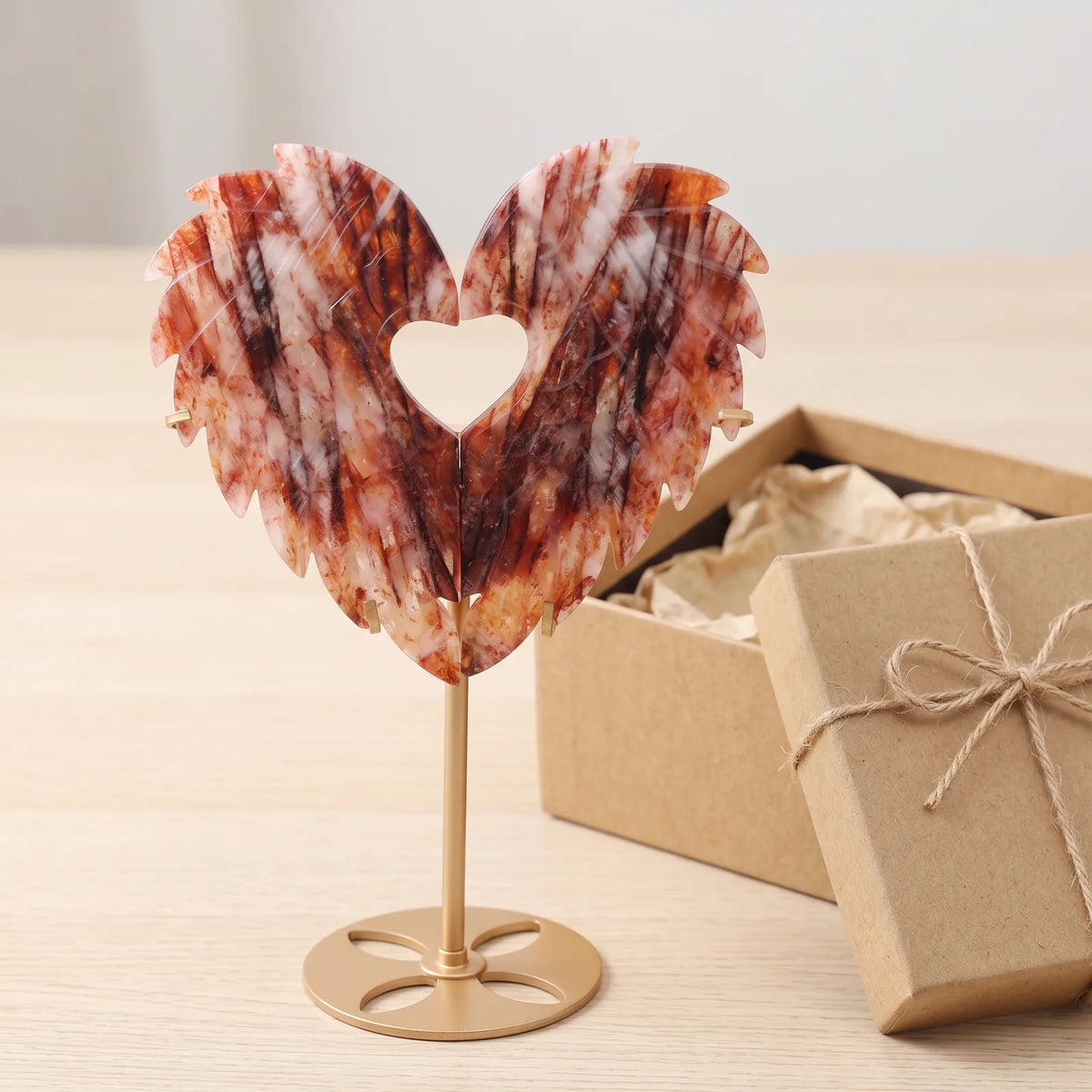 Grand cœur décoratif en cristal à côté d'une boîte cadeau kraft