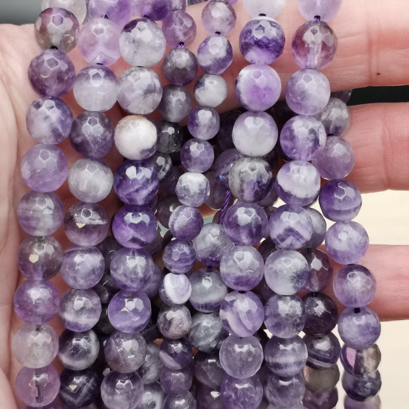 Détail des bandes violettes et blanches d'une perle d'améthyste chevron