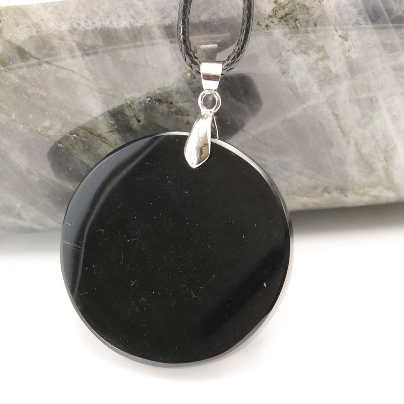Gravure du signe OM sur un disque d'obsidienne noire du Mexique
