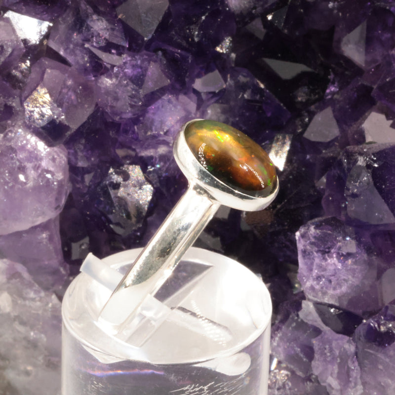 Bague opale noire portée au doigt, pièce unique en argent