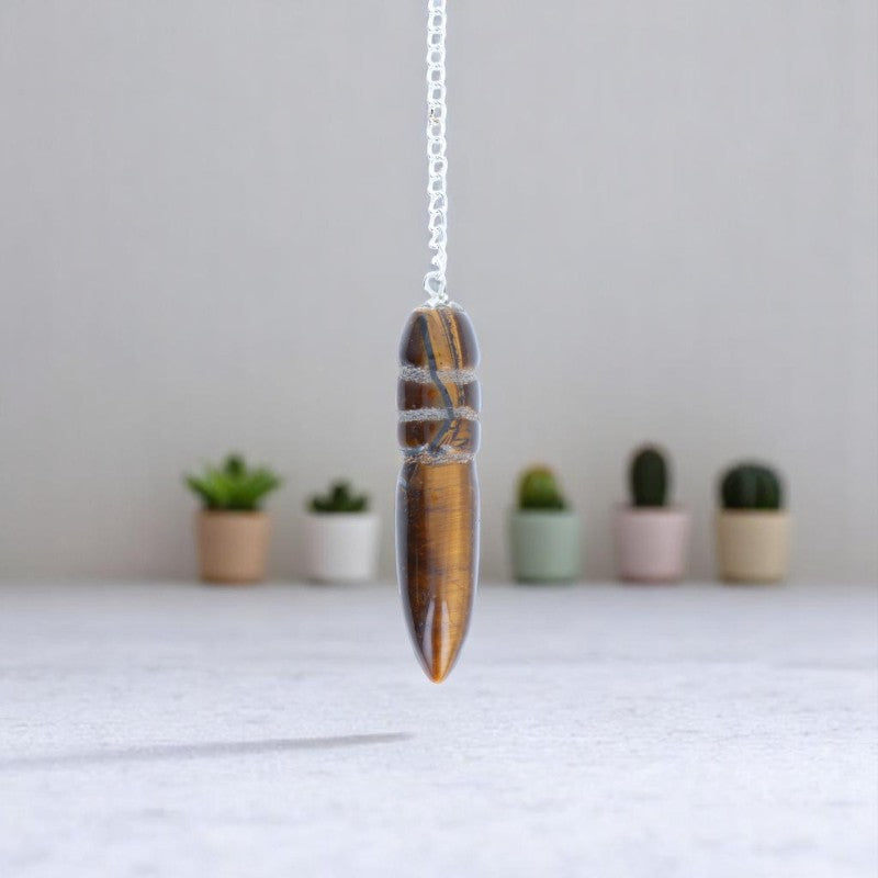 Gros plan sur la forme précise du Pendule Égyptien (Oeil de Tigre) en pierre naturelle