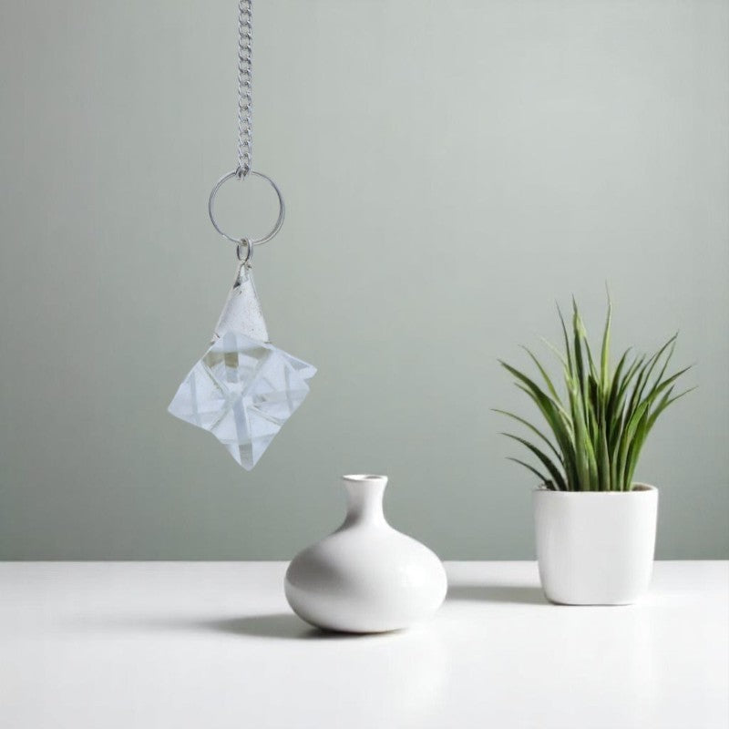 Gros plan sur la géométrie précise du Pendule Merkaba (Cristal de Roche) en quartz clair