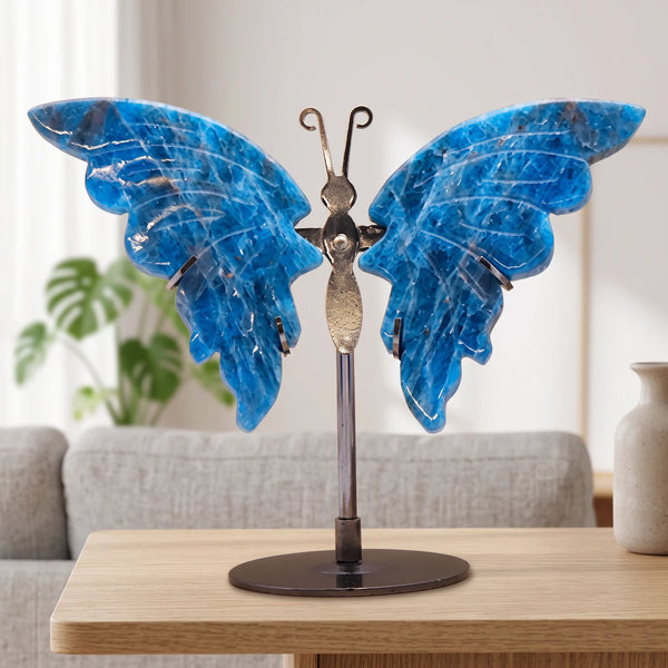 Papillon décoratif bleu en apatite sur socle argenté, posé sur une table dans un salon lumineux
