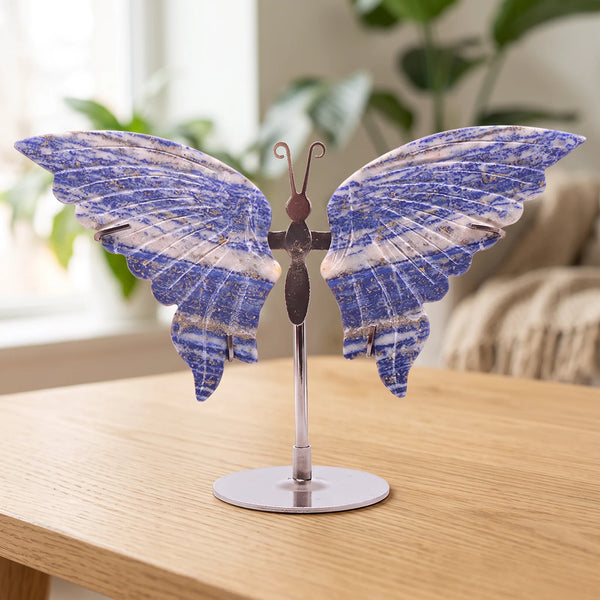 Papillon décoratif bleu en lapis lazuli sur socle argenté, posé sur une table dans un salon lumineux