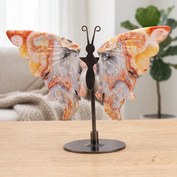 Papillon décoratif orange et gris en agate crazy lace sur socle, posé sur une table dans un salon lumineux