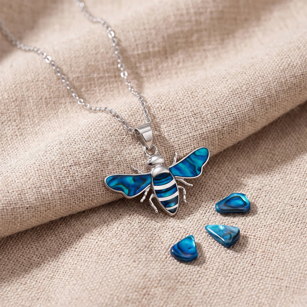 Pendentif abeille en nacre d'ormeau bleue sur un lin naturel avec des éclats de nacre