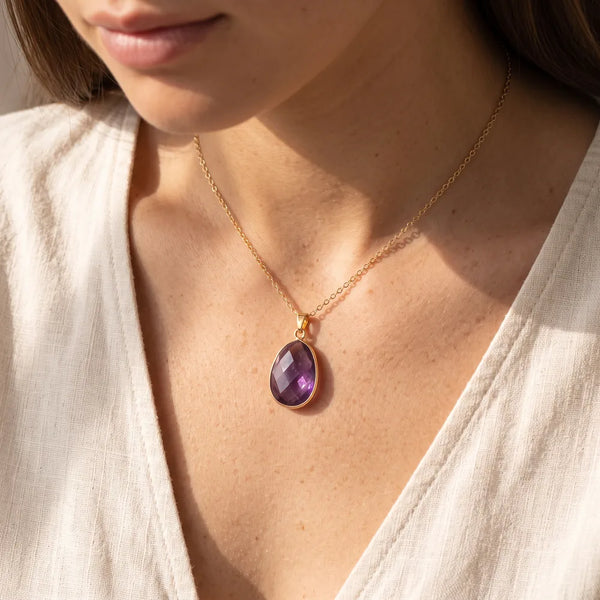 Pendentif améthyste porté par une femme, collier pierre violette sur chaîne dorée