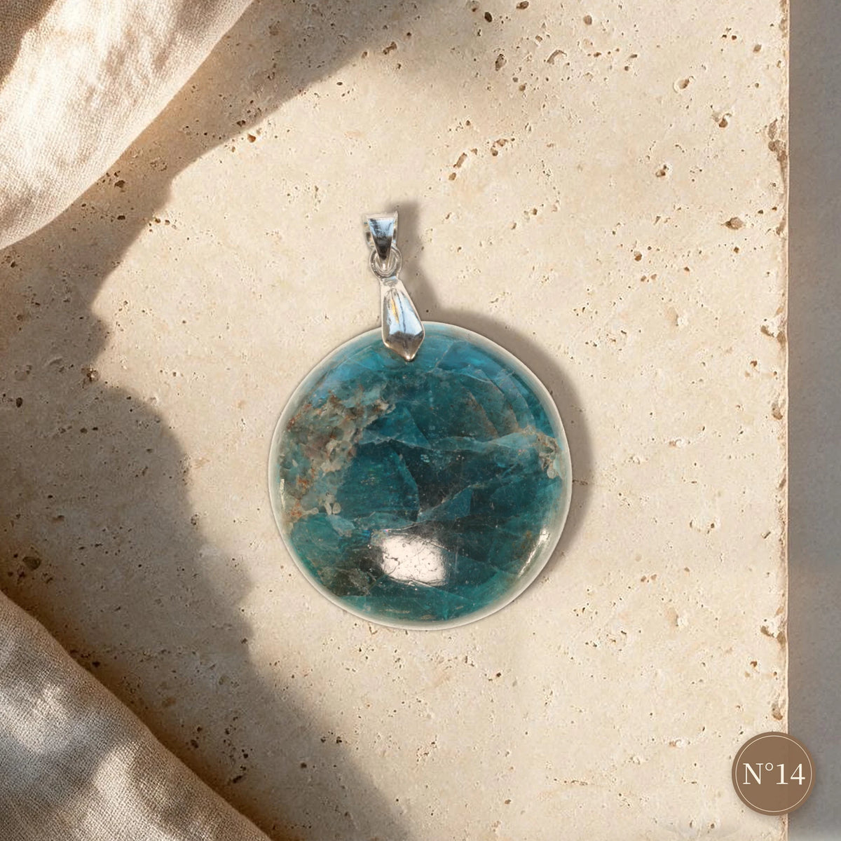 Pendentif apatite bleue pièce unique N°14, cabochon rond bleu nuit et turquoise, bélière argentée sur travertin