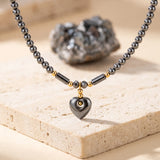Collier Cœur Femme en Hématite, Pendentif Cœur Bombé et Perle Dorée