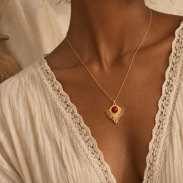 Pendentif cornaline SOLENA® porté par une femme, soleil doré sur chaîne fine
