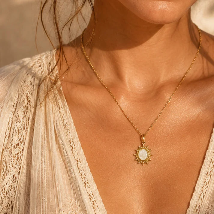 Pendentif cristal de roche ALBA® porté par une femme, soleil doré sur chaîne fine