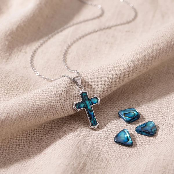 Pendentif croix en nacre d'ormeau bleue sur un lin naturel avec des éclats de nacre