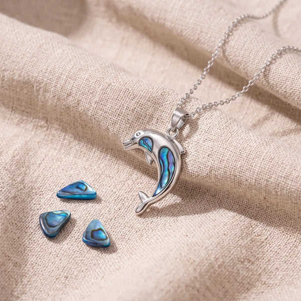 Pendentif dauphin en nacre d'ormeau bleue sur un lin naturel avec des éclats de nacre
