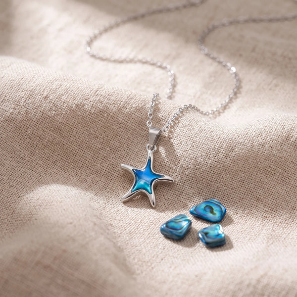 Pendentif étoile de mer en nacre d'ormeau bleue sur un lin naturel avec des éclats de nacre