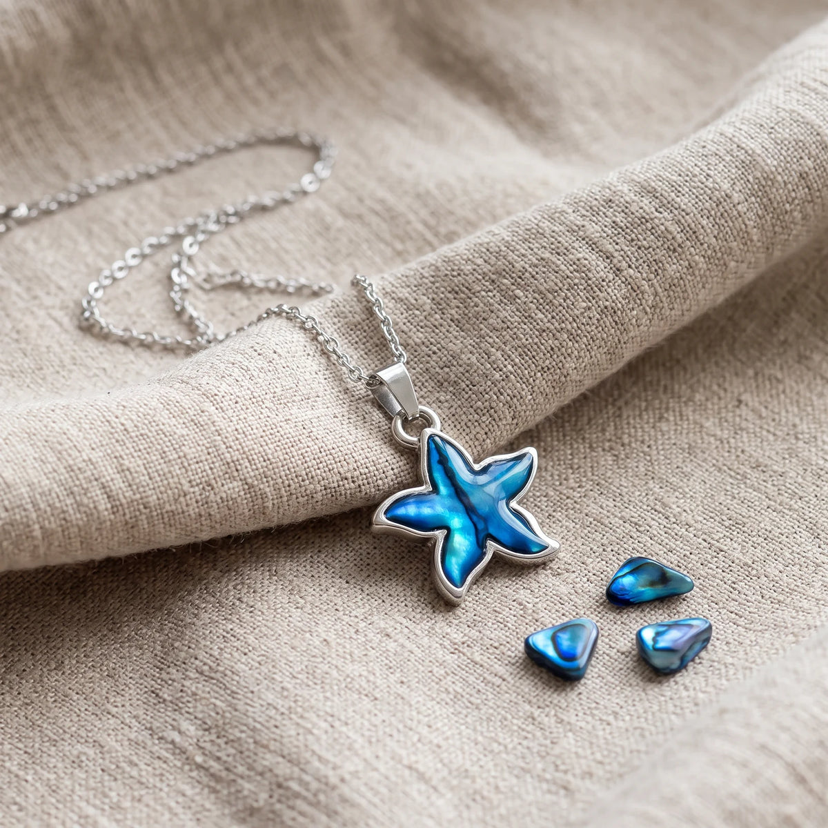 Pendentif fleur en nacre d'ormeau bleue sur un lin naturel avec des éclats de nacre