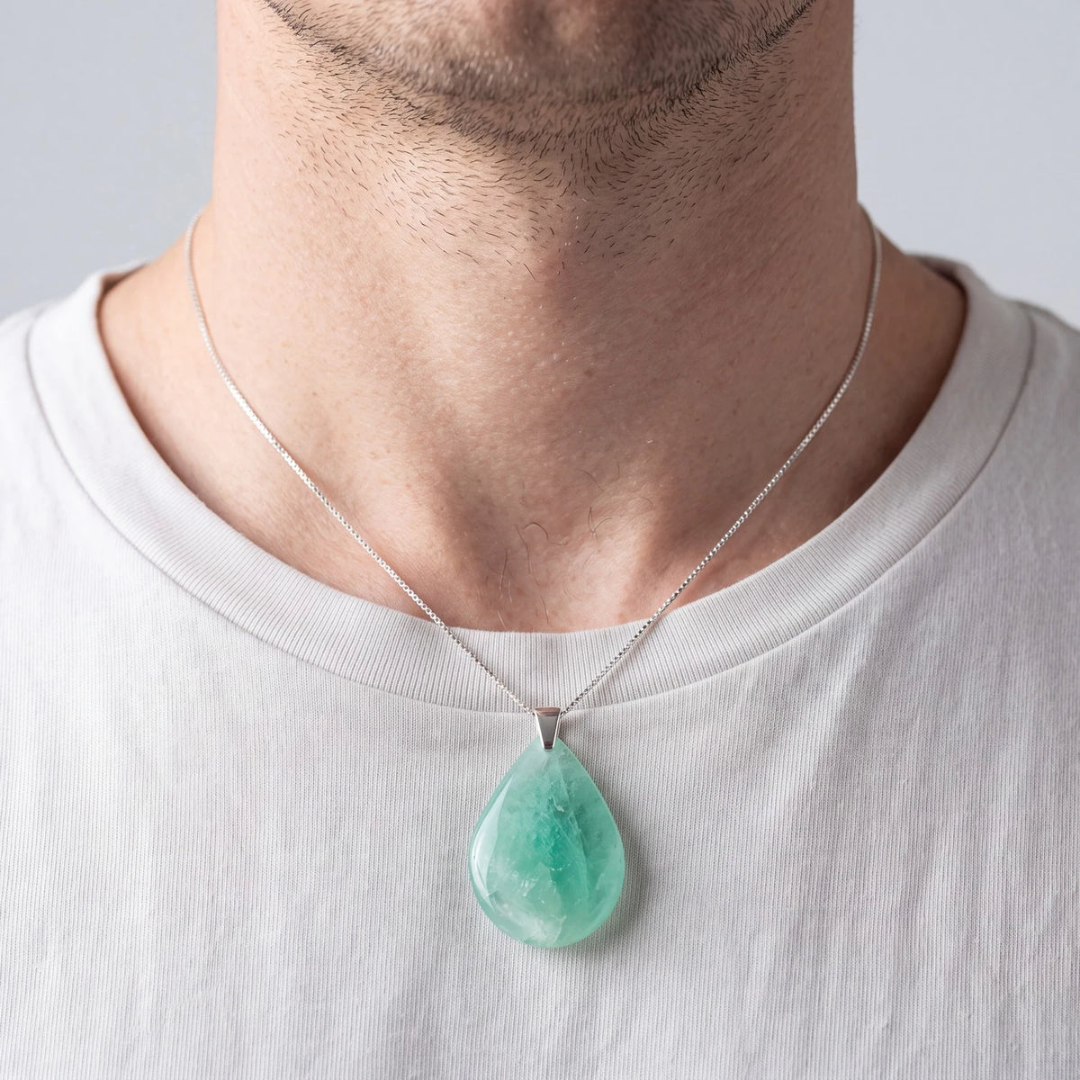Pendentif pierre fluorine verte en goutte porté par un homme sur une chemise ouverte