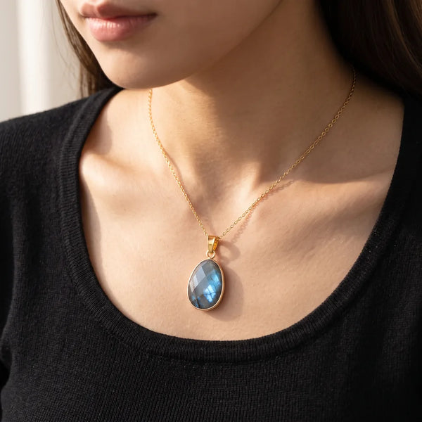 Pendentif labradorite porté par une femme, collier pendentif femme sur chaîne dorée
