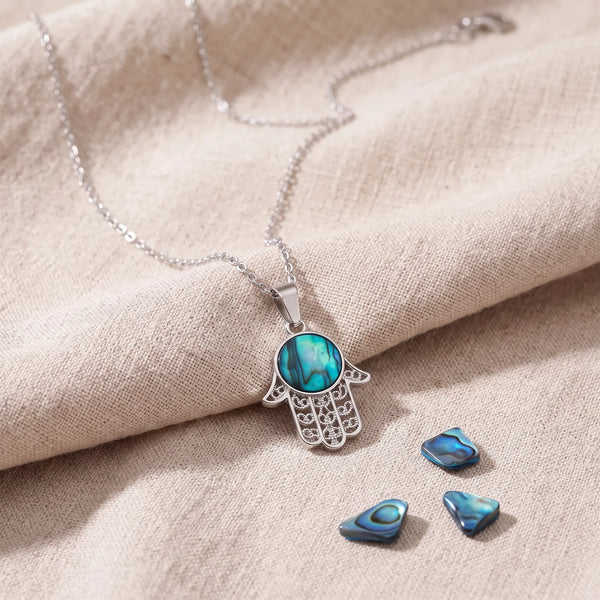 Pendentif main de Fatma en nacre d'ormeau bleue sur un lin naturel avec des éclats de nacre
