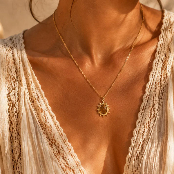 Pendentif œil de tigre ALBA® porté par une femme, soleil doré sur chaîne fine