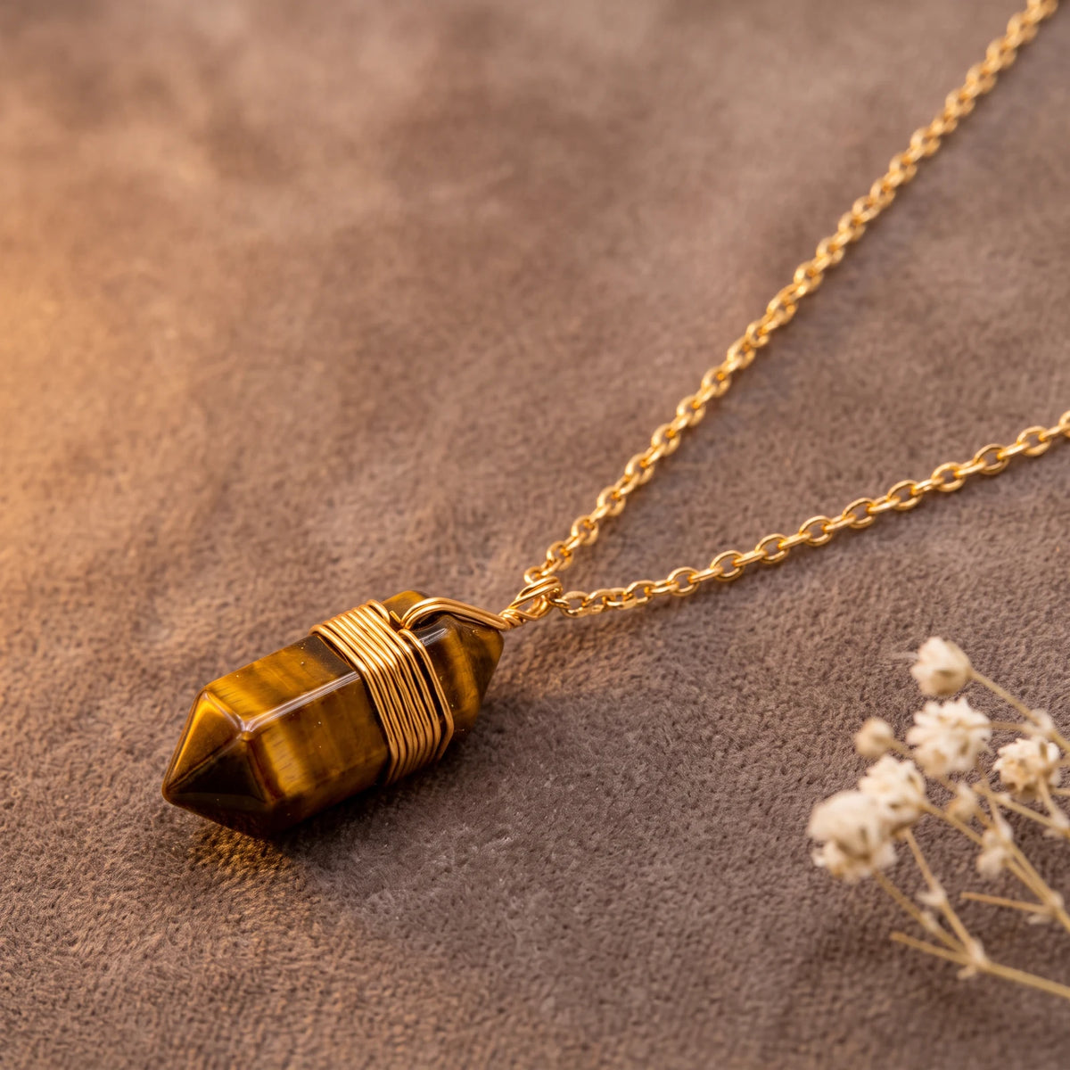 Pendentif œil de tigre en pointe chatoyante, fil doré enroulé