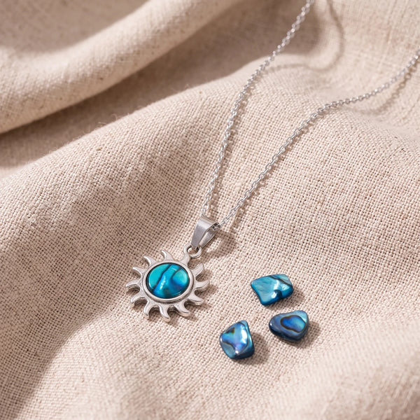 Pendentif petit soleil en nacre d'ormeau bleue sur un lin naturel avec des éclats de nacre