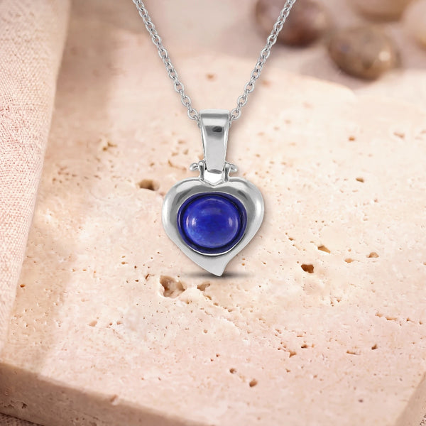 Collier lapis lazuli véritable, modèle en cœur d'argent, sur sa chaîne, posé sur une dalle de travertin