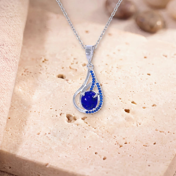 Collier lapis lazuli pierre naturelle, modèle ovale dans une goutte d'argent ajourée, sur une dalle de travertin