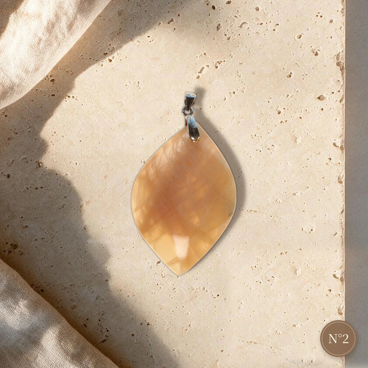 Pendentif pierre de lune pêche pièce unique N°2, feuille translucide orange et bélière argentée sur travertin