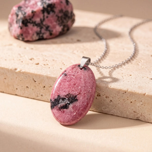 Pendentif pierre rose ovale en rhodonite naturelle, veinée de noir, sur chaîne argentée et travertin