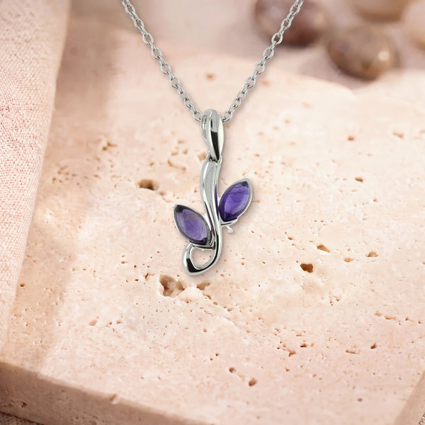Collier améthyste véritable, modèle deux feuilles sur une branche d'argent, sur sa chaîne, posé sur une dalle de travertin
