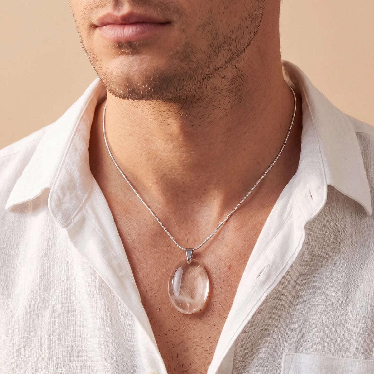 Pendentif quartz fumé homme, ovale plat brun porté sur une chemise en lin beige