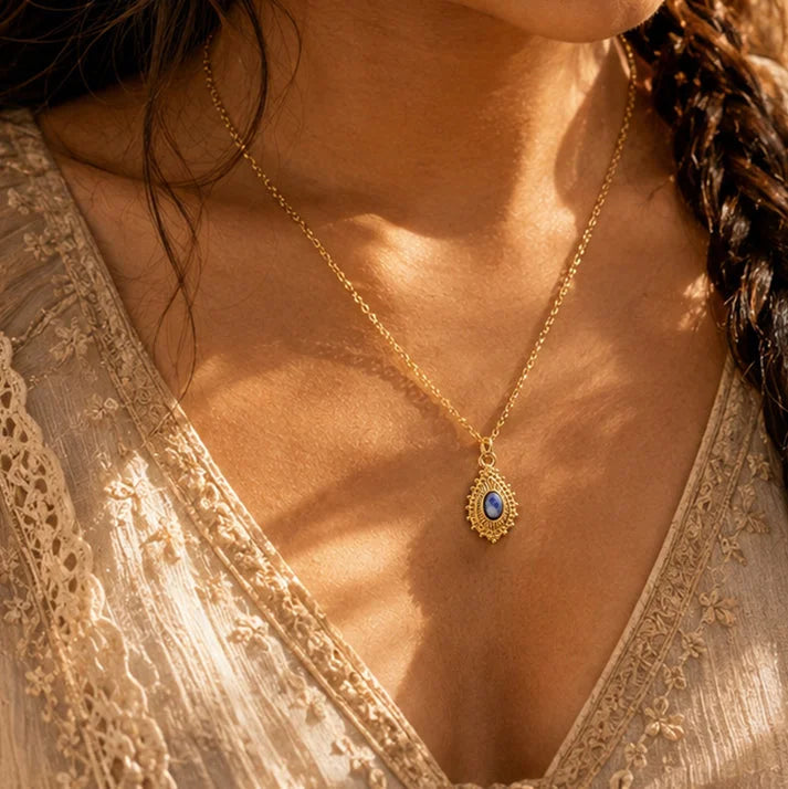 Pendentif sodalite ORIANE® porté par une femme, médaillon doré sur chaîne fine